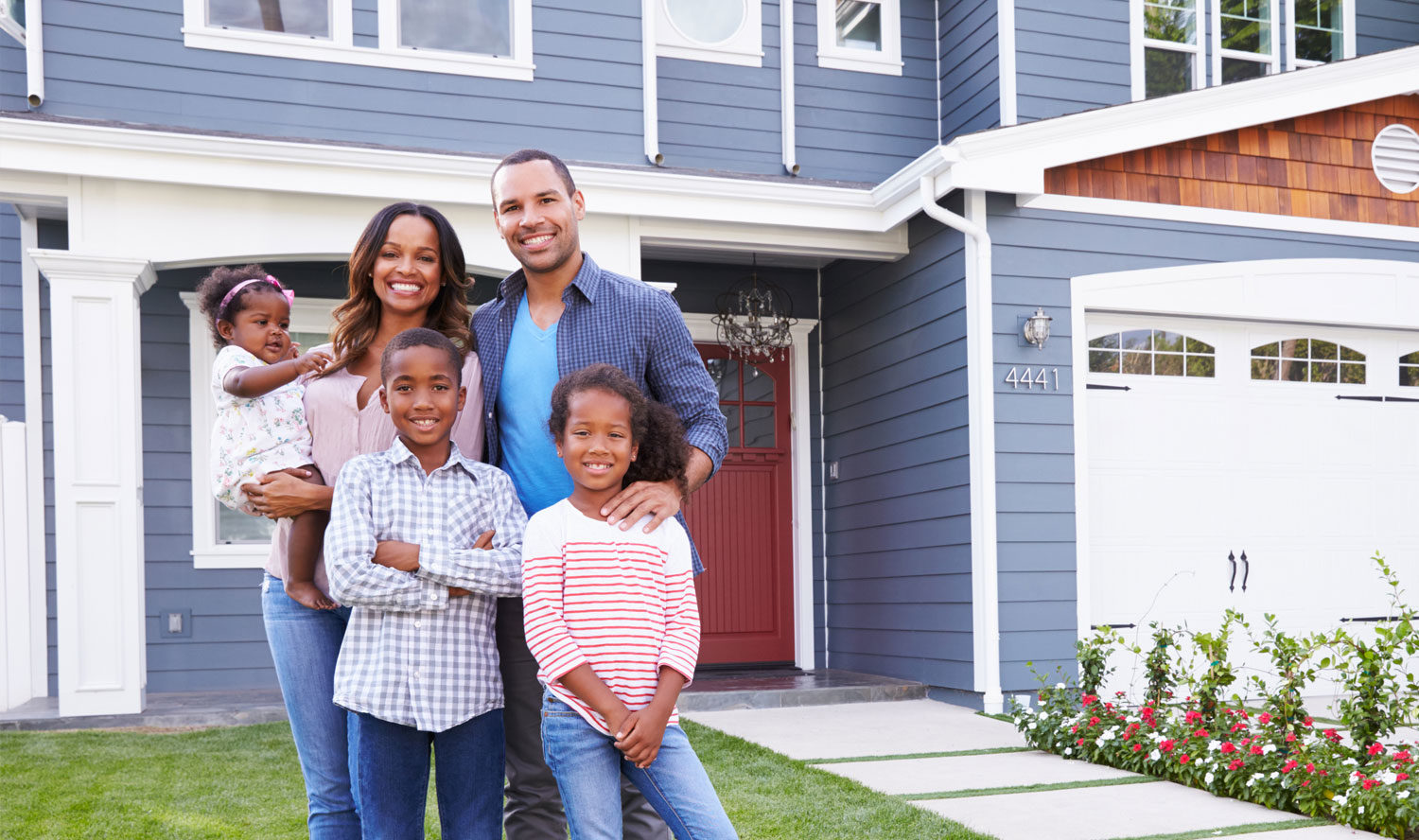 Family of 5 standing outside home