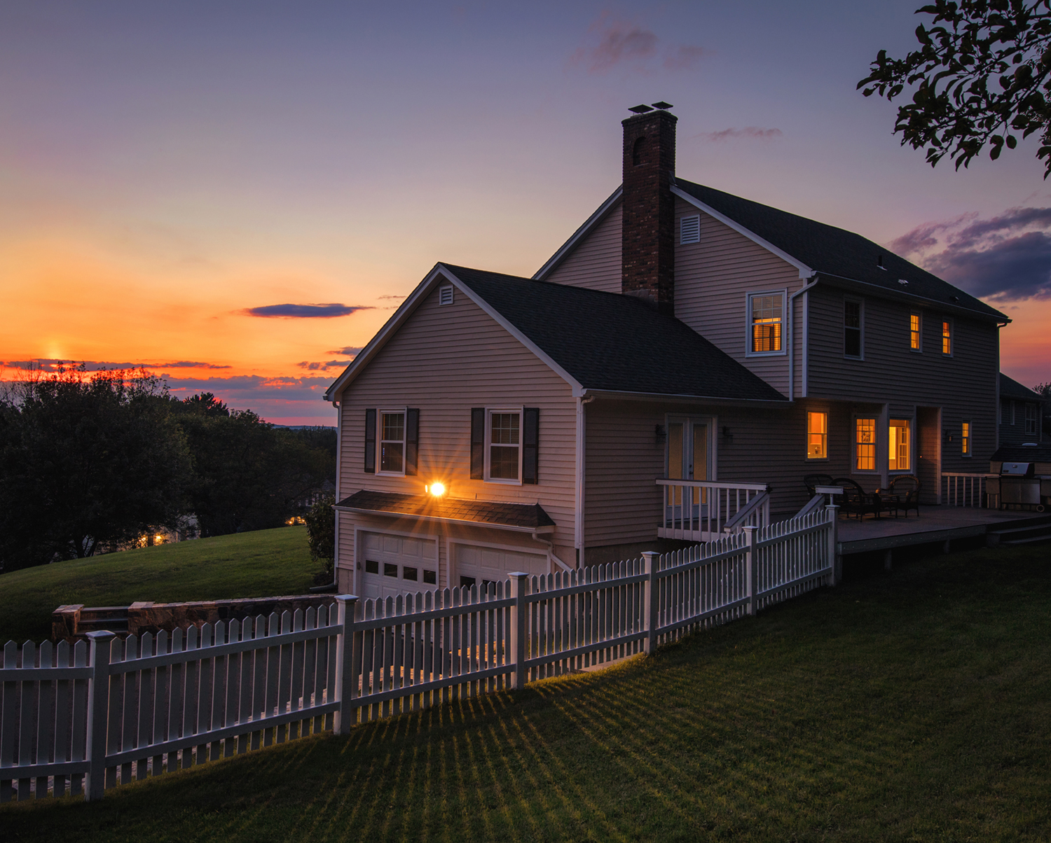 Home with lights on at sunset