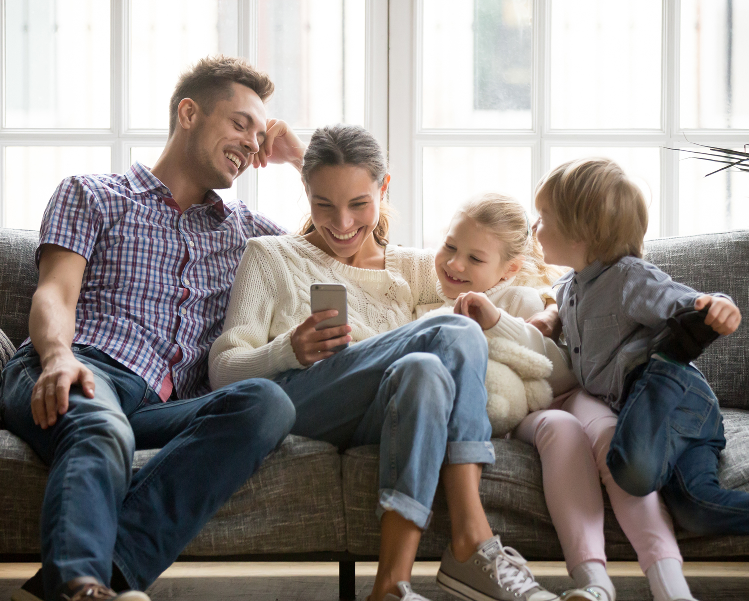 Family on couch looking at smartphone